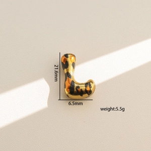 Vista de detalle del colgante letra L dorado con estampado de leopardo y 21,6 mm de alto