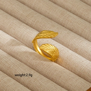 Detail of 18K gold-plated stainless steel ring with textured wing design and adjustable band