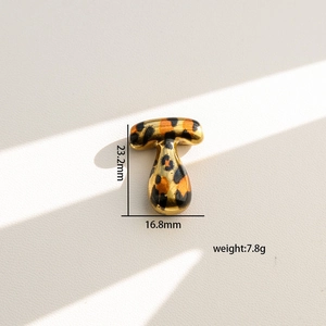 Detalle del colgante letra T dorado con estampado de leopardo y medidas de 23,2mm