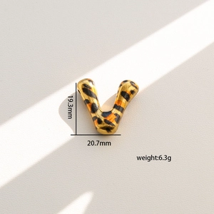 Detalle del colgante letra V con estampado de leopardo y medidas de tamaño en dorado