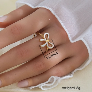 Elegante anillo de lazo bañado en oro de 18K con textura tejida y diseño de cinta blanca