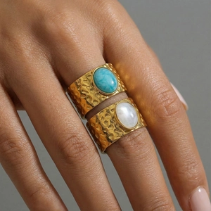 Hammered gold stainless steel rings with turquoise and moonstone on model's fingers