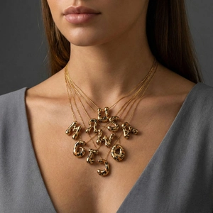 Collar dorado minimalista con colgantes de letras irregulares en esmalte de leopardo