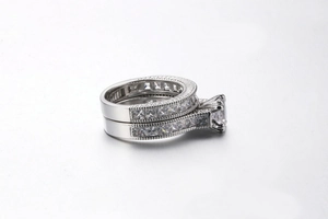 Close-up of platinum bridal set featuring princess cut zircon and milgrain edge details
