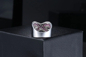 Macro shot of silver mask ring with heart patterns and paved pink zircons