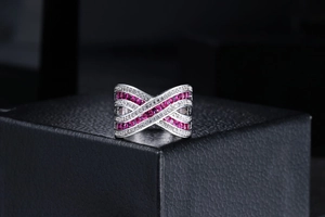 Close-up of silver criss-cross ring with pink square stones and white round diamonds