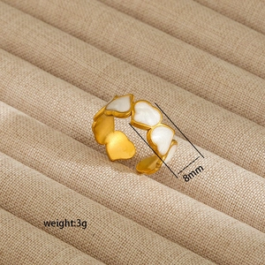 Detail view of an 8mm wide golden open ring featuring white enamel hearts, weight 3g