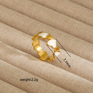 Detailed view of 7.1mm irregular gold-plated heart ring with white enamel accents
