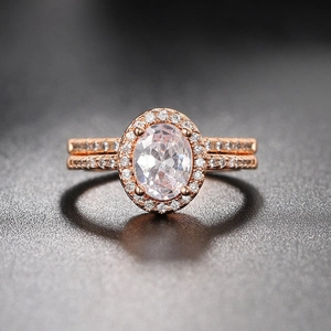 Macro shot of rose gold engagement ring with oval halo zircon and double pavé bands