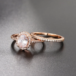 Macro side view of rose gold engagement ring set with oval halo diamond and pave band