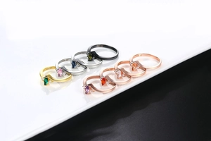 Macro detail of multicolored marquise zircon rings with 18K GP engraving on bands