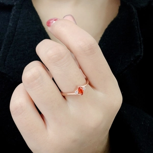 Elegant rose gold ring with orange marquise-cut stone and side diamonds on hand