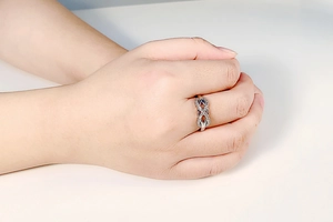 Close-up of women's silver infinity ring with micro-paved zircons on a hand