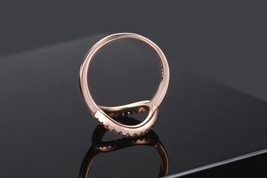 Detailed macro view of rose gold V-shaped ring band with brilliant zircon micro-pave setting