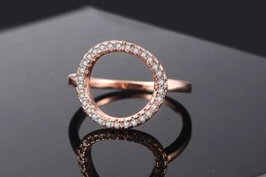 Macro shot of rose gold ring with hollow O-shape set and sparkling zircon accents