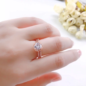 Klassieke roségouden trouwringset met zirkonia halo gedragen aan de hand