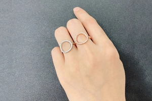 Detail of rose gold and silver O-ring jewelry with pavé cubic zirconia settings