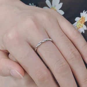 Anillo plateado trenzado para mujer con circonitas micro-pavé mostrado en el dedo