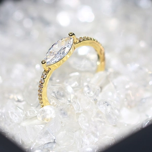 Elegant 14k gold plated marquise cut zircon ring with micro-pave side stones on icy background