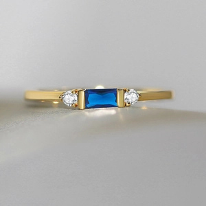 Macro shot of 14K gold plated ring featuring a rectangle blue gemstone and zircon accents