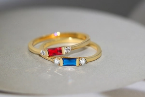 Detailed close-up of 14K gold plated rings featuring emerald and ruby cut zircon stones