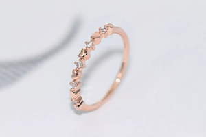 Close-up of rose gold ring with alternating heart shapes and sparkling zircons