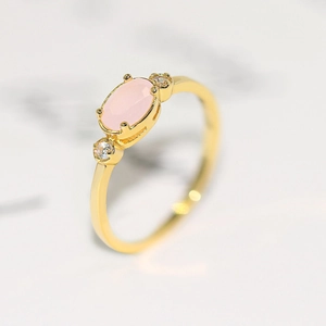 Elegant 14k gold plated ring featuring an oval pink gemstone with round zircon accents