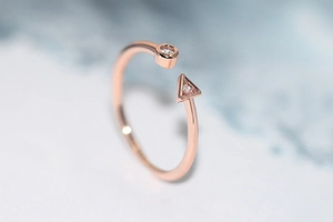 Detailed macro view of rose gold open ring with round and triangle zircon stones