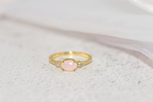 Macro shot of 14k gold plated ring featuring oval pink gemstone with zircon accents
