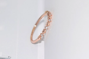 Macro view of slender rose gold heart ring featuring delicate pave cubic zirconia settings