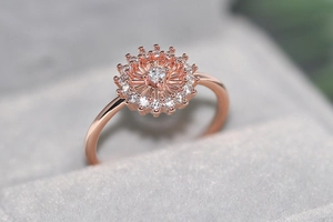 Detalle macro del anillo de girasol en oro rosa con circonitas sobre terciopelo gris