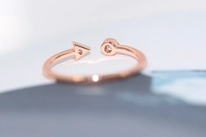 Detailed close-up of rose gold geometric ring featuring triangle and circle zircon inlays