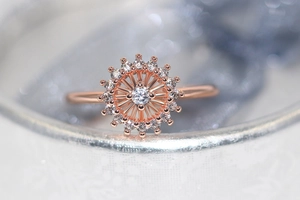 Primer plano macro de un anillo girasol de oro rosa con circonitas y acabado detallado