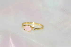 Macro shot of 14k gold plated ring with pink oval crystal and cubic zirconia side stones