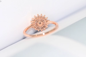 Detalle macro del anillo floral hueco de oro rosa con piedras de circón claras