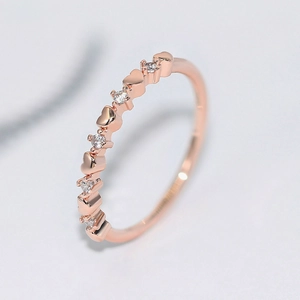 Rose gold heart ring with small white cubic zirconia stones in 45-degree side view