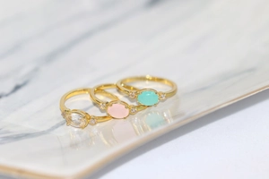 Macro detail of three 14k gold plated rings with colorful oval zircon center stones