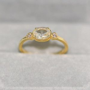 Polished 14k gold plated ring featuring an oval zircon center stone in a four-prong setting