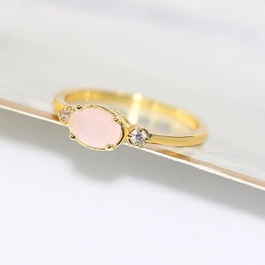 Elegant 14k gold plated ring featuring a pink oval gemstone and side zircon accents