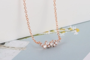 Detailopname van de roségouden ketting met een cluster van witte zirkonia-stenen