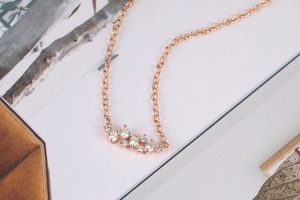 Macro-opname van de roségouden hanger met zirkooncluster aan een fijne ketting