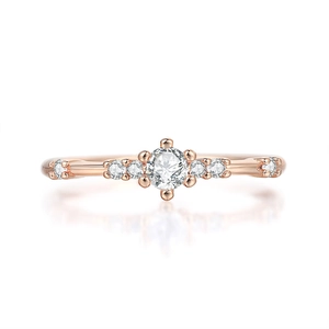 Detail view of the rose gold ring featuring seven sparkling diamonds with six-prong setting