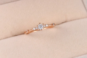 Detailed macro shot of rose gold ring featuring 7 brilliant zircons on beige velvet