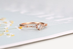 Detailed view of rose gold vine ring with small diamonds on floral background