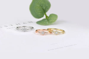 Detailed close-up of three minimalist rings in gold, silver, and rose gold finishes