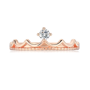 Macro detail of rose gold crown ring featuring a sparkling central zircon and bead edge