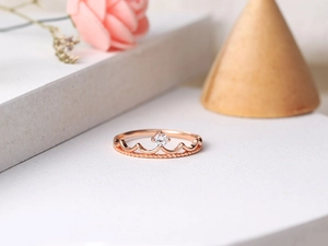 Macro view of rose gold crown ring with sparkling zircon and beaded edge detailing