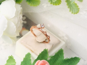 Detailed macro view of a rose gold crown ring featuring a central sparkling zircon stone