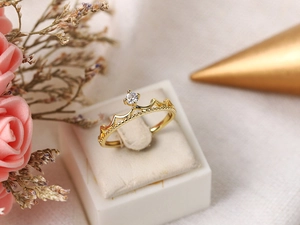 Detailed view of a gold crown ring with zircon in a white jewelry gift box