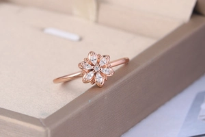 Detail of rose gold flower ring featuring marquise-cut zircon petals on jewelry box